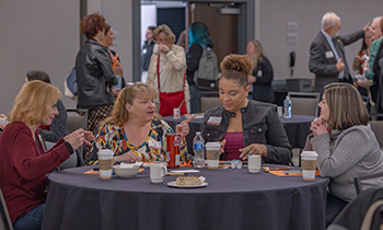 four women sitting around a table sharing ideas